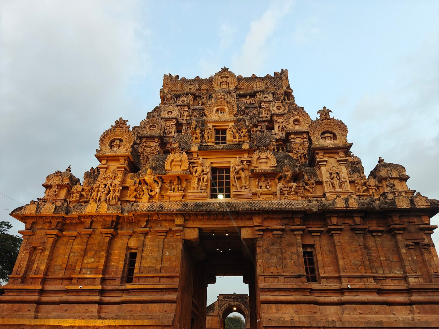 The elaborately carved entrance gopuram of Brihadisvara Temple, Thanjavur — layers of Chola-era sculpture in warm sandstone